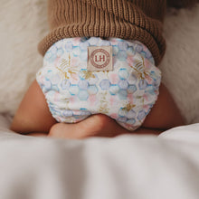 Load image into Gallery viewer, Toddler wearing a Lighthouse Kids Supreme all-in-one cloth nappy - Opal Hive print - Peanut and Poppet UK