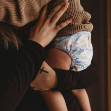 Load image into Gallery viewer, Baby wearing Lighthouse Kids pocket cloth nappy - Opal Hive print - Peanut and Poppet UK