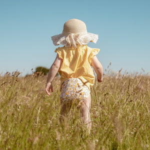 Toddler in a field wearing Little Lovebum Quickdry in Buttercup - All-in-One Cloth Nappy - Peanut and Poppet UK